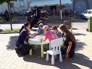 Policjantki przy stoiskach promocyjnych z uczestnikami wydarzenia