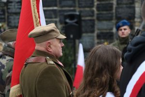 Policjanci i uczestnicy uroczystości pod pomnikiem Sybiraków oraz ofiar zbrodni katyńskiej.